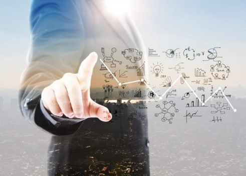 businessman-pointing-graphs-and-symbols-1200x855
